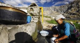 Women pumping water with the Himalayan mountains in the background, Nepal